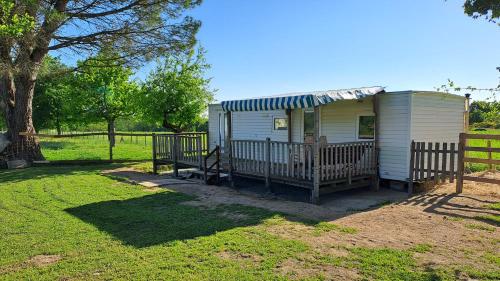 a tiny house with a porch and a fence at Le fief in Le Tablier