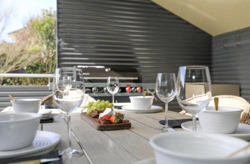 a table with wine glasses and a plate of food at Kurupae House - Taupo Central in Taupo