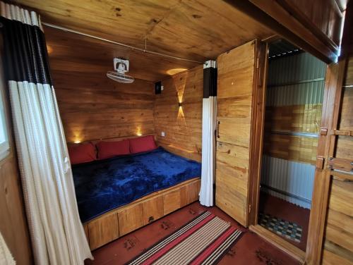 a small room with a bed in a wooden house at DIAMOND HILL VIEW in Ketti