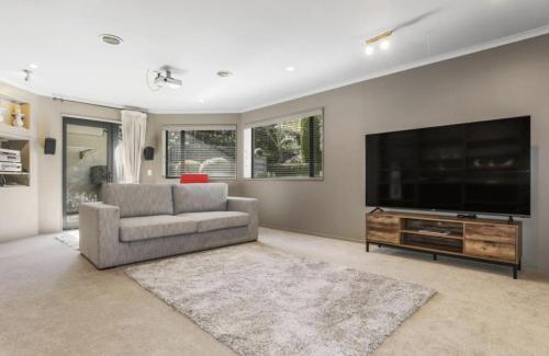 a living room with a flat screen tv and a couch at Kurupae House - Taupo Central in Taupo