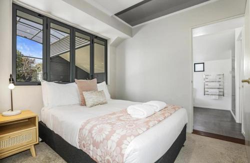 a white bedroom with a bed and a window at Kurupae House - Taupo Central in Taupo