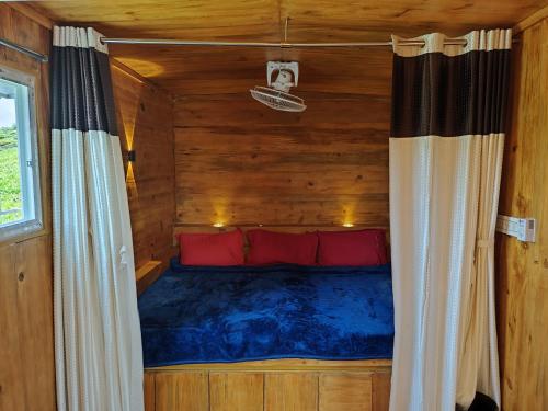 a bedroom with a bed in a wooden cabin at DIAMOND HILL VIEW in Ketti