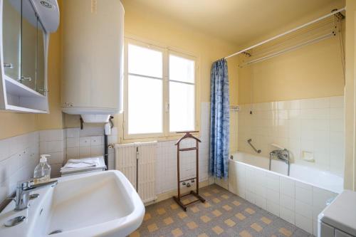 La salle de bains est pourvue d'un lavabo, d'une baignoire et d'une fenêtre. dans l'établissement Sunny apartment with balcony, à Menton