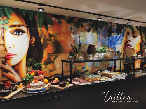 ein Buffet mit einem Wandgemälde einer Frau in der Unterkunft Stay by Triller - Aparthotel in Saarbrücken