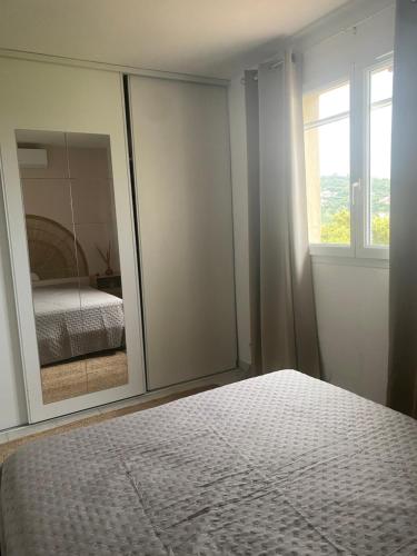 - une chambre avec un miroir, un lit et une fenêtre dans l'établissement Appartement avec piscine, vue golf à sainte Maxime, à Sainte-Maxime