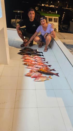 a man and a woman sitting next to a row of fish at Splendour Grand in Maalhos