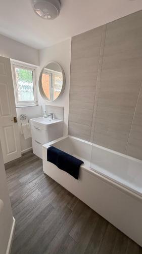 a white bathroom with a tub and a sink at Malvern Hills House in Great Malvern