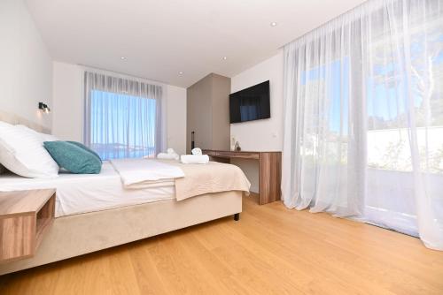 a bedroom with a large bed and a large window at Villa Oasis in Trogir