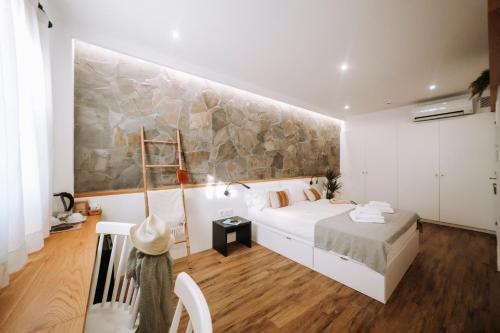 a bedroom with a white bed and a stone wall at Murada hotel in Ciutadella
