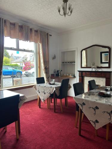 - une salle à manger avec une table, des chaises et un miroir dans l'établissement Tay Villa, à Inverness