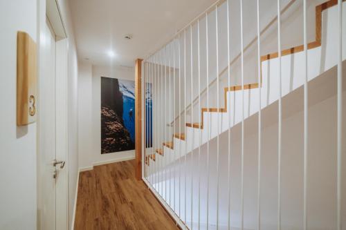 a hallway with white walls and wooden stairs at Murada hotel in Ciutadella