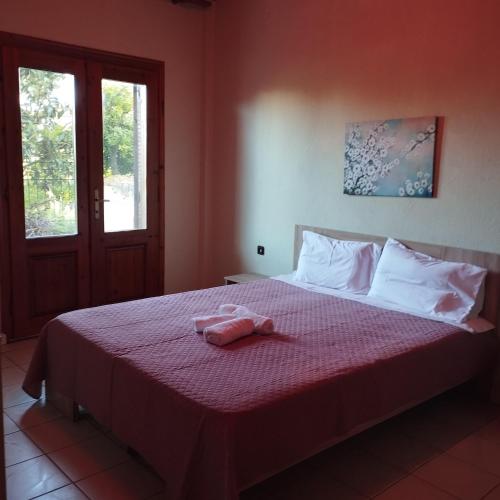 a bedroom with a bed with a pink towel on it at Michael House in Kavala