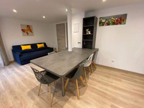 un salon avec une table, des chaises et un canapé dans l'établissement Gite du jardin, à Diebolsheim