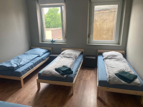 two beds in a room with two windows at EMAS 7 Wohnung mit 4 Einzelbetten, Küche, Dusche in Krefeld