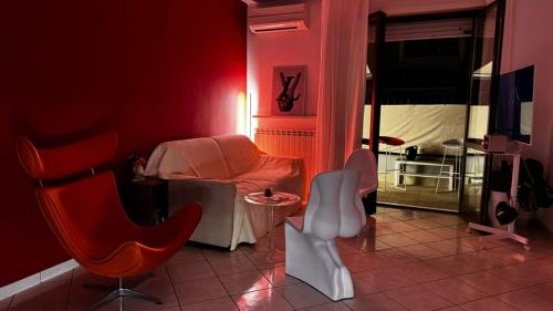 ein rotes Zimmer mit einem Bett und einem Tisch und Stühlen in der Unterkunft Casa SUN in Civitanova Marche