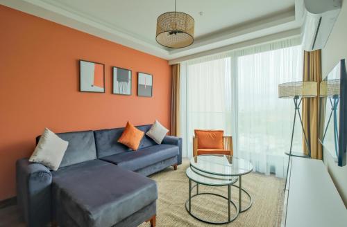 a living room with a blue couch and a glass table at Modern Furnished Apartments in Istanbul Basaksehir By Iradah Gayrimenkul in Basaksehir