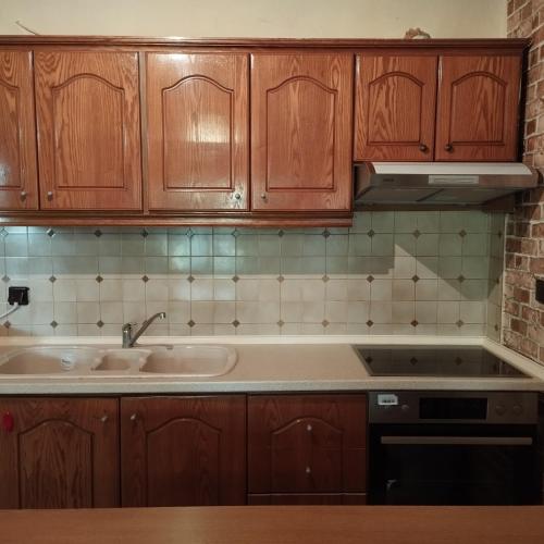 a kitchen with wooden cabinets and a sink at Michael House in Kavala