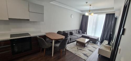 a kitchen and living room with a table and chairs at Modern Furnished Apartments in Istanbul Basaksehir By Iradah Gayrimenkul in Basaksehir