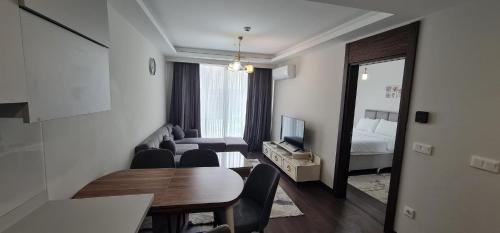 a living room with a table and a room with a bed at Modern Furnished Apartments in Istanbul Basaksehir By Iradah Gayrimenkul in Basaksehir