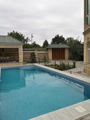 a large blue swimming pool next to a building at Holiday inn Adnan boutique hotel and pool in Gabala