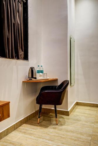 a black chair sitting in front of a table at Hotel Bawa Guest House in New Delhi