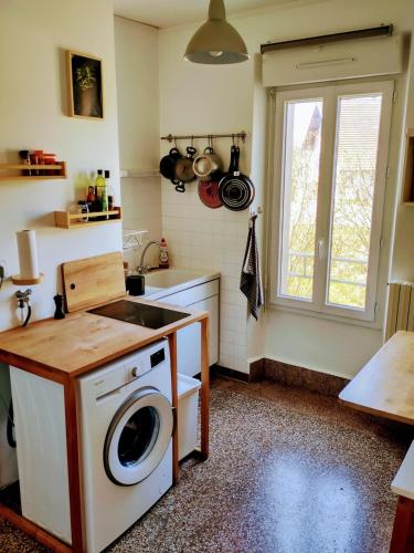 une cuisine avec une machine à laver et un évier dans l'établissement Le repaire du randonneur, à Lompnes