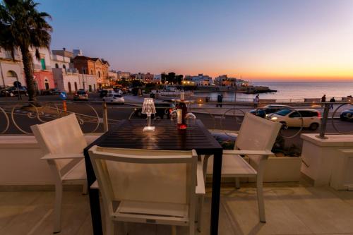 a table and chairs on a balcony with a view of the ocean at Lo Scirocco in Nardò