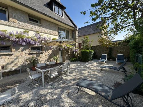 een terras met een tafel, stoelen en een parasol bij Maison Hyper centre Dinan 2,4 ou 6 personnes in Dinan
