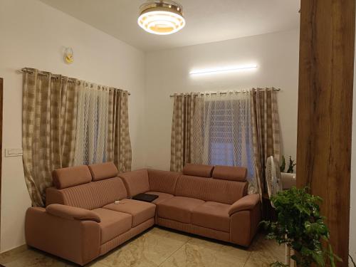 a living room with a brown couch and curtains at La casona in Kottayam