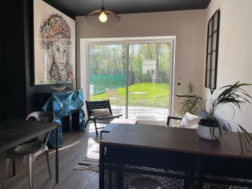 un salon avec une cheminée et une grande fenêtre dans l'établissement La Chênaie - Les Charmilles, à Gien