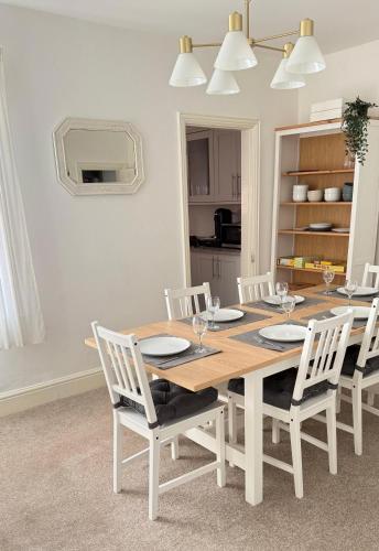 a wooden table with white chairs and a dining room at Malvern Hills House in Great Malvern