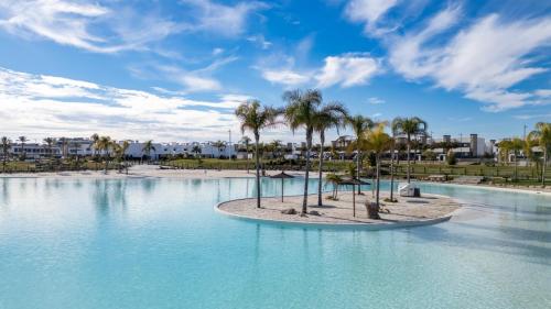 a large pool with palm trees in a resort at Santa Rosalía Lake & Life Resort Penthouse in Torre-Pacheco