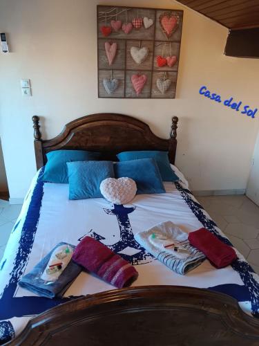 un lit avec des oreillers bleus et un couvre-lit avec des cœurs dessus dans l'établissement Casa del Sol - Location de vacances, 3 étoiles avec terrasse cosy, clim et 3mn de la plage et des commerces, animaux admis,wifi, au Barcarès