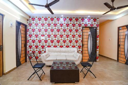 a living room with a white couch in front of a wall at Comfort Stays Kolkata airport in Salua
