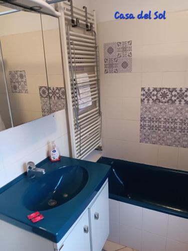 La salle de bains est pourvue d'un lavabo bleu et d'une baignoire. dans l'établissement Casa del Sol - Location de vacances, 3 étoiles avec terrasse cosy, clim et 3mn de la plage et des commerces, animaux admis,wifi, au Barcarès