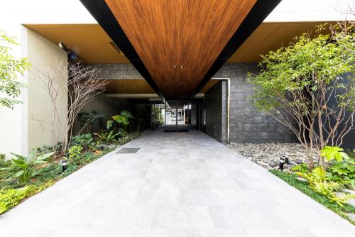 a walkway leading to a building with a wooden ceiling at LIVEIL Hakataekimae in Fukuoka
