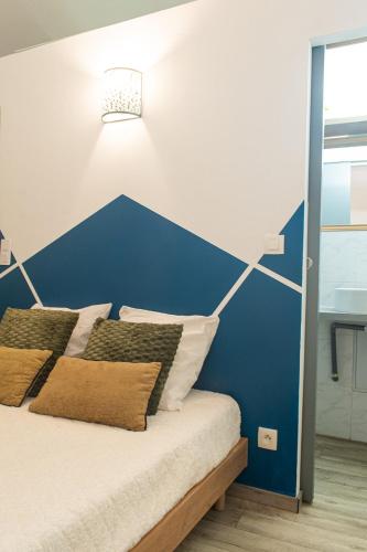 un lit dans une chambre avec un mur bleu dans l'établissement Seven Keys - Le nid de Payre, au Pouzin