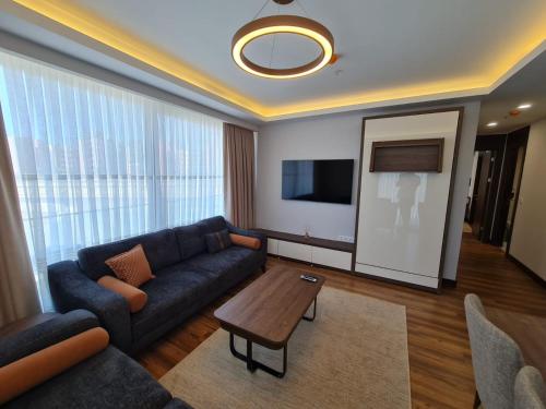 a living room with a couch and a table at Modern Furnished Apartments in Istanbul Basaksehir By Iradah Gayrimenkul in Basaksehir