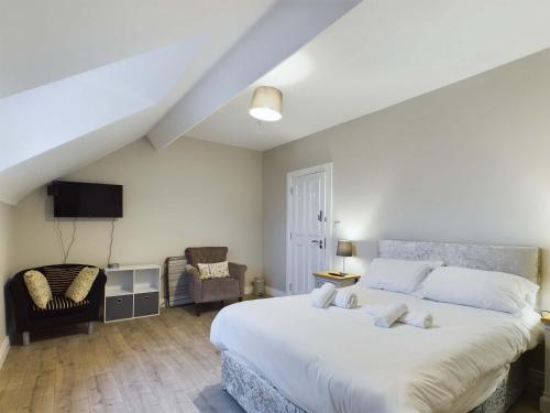 a bedroom with a large white bed and a chair at Luxurious 5 Bedroom Home near City Centre in Belfast