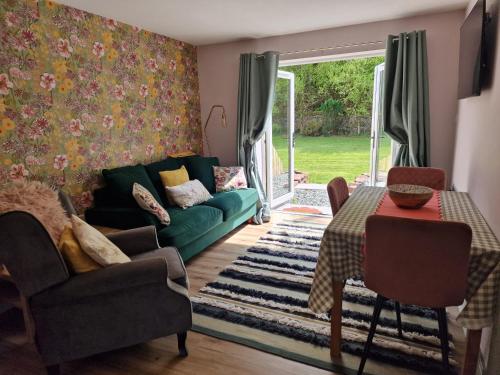 a living room with a green couch and a table at The Burrow by Blake View Holidays a peaceful boutique retreat 3 miles from Ennerdale- standard twin or super-king bed available in Rowrah