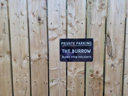 a sign on a wooden fence that reads private parking the burrow at The Burrow by Blake View Holidays a peaceful boutique retreat 3 miles from Ennerdale- standard twin or super-king bed available in Rowrah