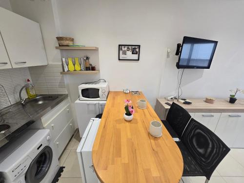 une petite cuisine avec une table en bois et un four micro-ondes dans l'établissement Sunny Prom Studio, à Nice