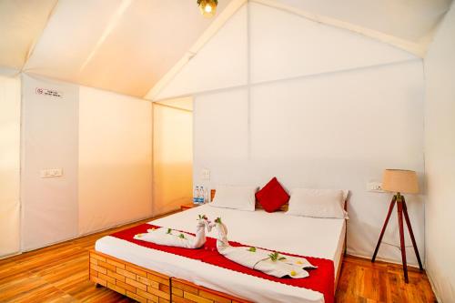 a bedroom with a bed with two swans on it at Kabila Camp in Kasol