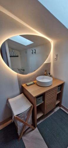 une salle de bain avec un lavabo et un miroir dans l'établissement Maison de ville en pierre - 6 couchages, à Villeuneuve-de-Berg