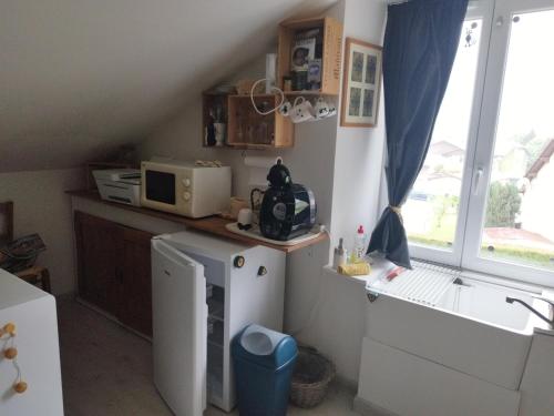 une petite cuisine avec un micro-ondes et un réfrigérateur dans l'établissement La chambre CHAT,au coeur des Vosges, à Ferdrupt