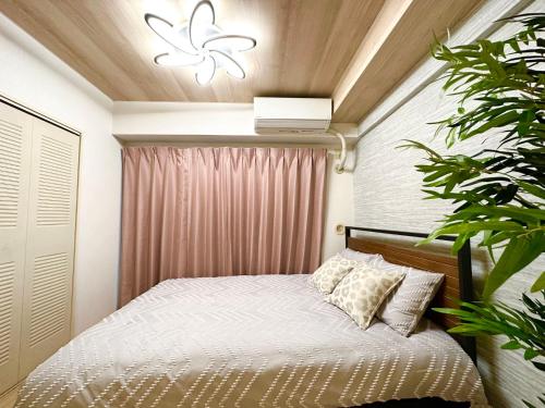 a small bedroom with a bed and a plant at a404涉谷区域 乘电车4分钟到达新宿 巴士直达涉谷步行到西新宿五丁目8分钟 max6 in Tokyo