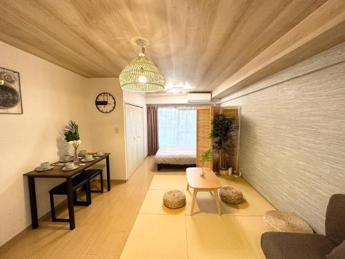 a living room with a table and a room with a bed at a404涉谷区域 乘电车4分钟到达新宿 巴士直达涉谷步行到西新宿五丁目8分钟 max6 in Tokyo