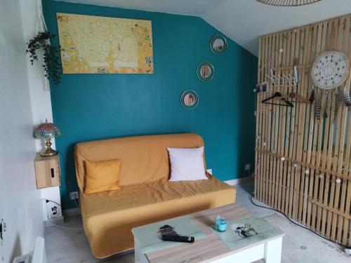 un salon avec un canapé et un mur bleu dans l'établissement La chambre CHAT,au coeur des Vosges, à Ferdrupt