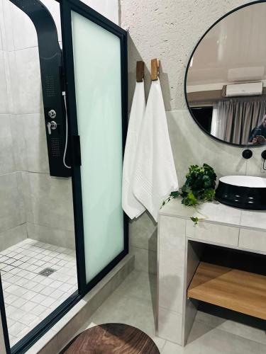 a bathroom with a shower and a sink and a mirror at Impèrio Boutique Guest Lodge in Siyabuswa