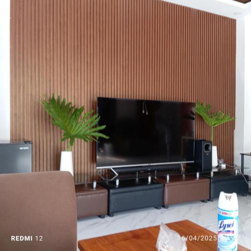 a living room with a large flat screen tv on a wall at Jachim and Boaz FarmVille Staycation in Tagaytay
